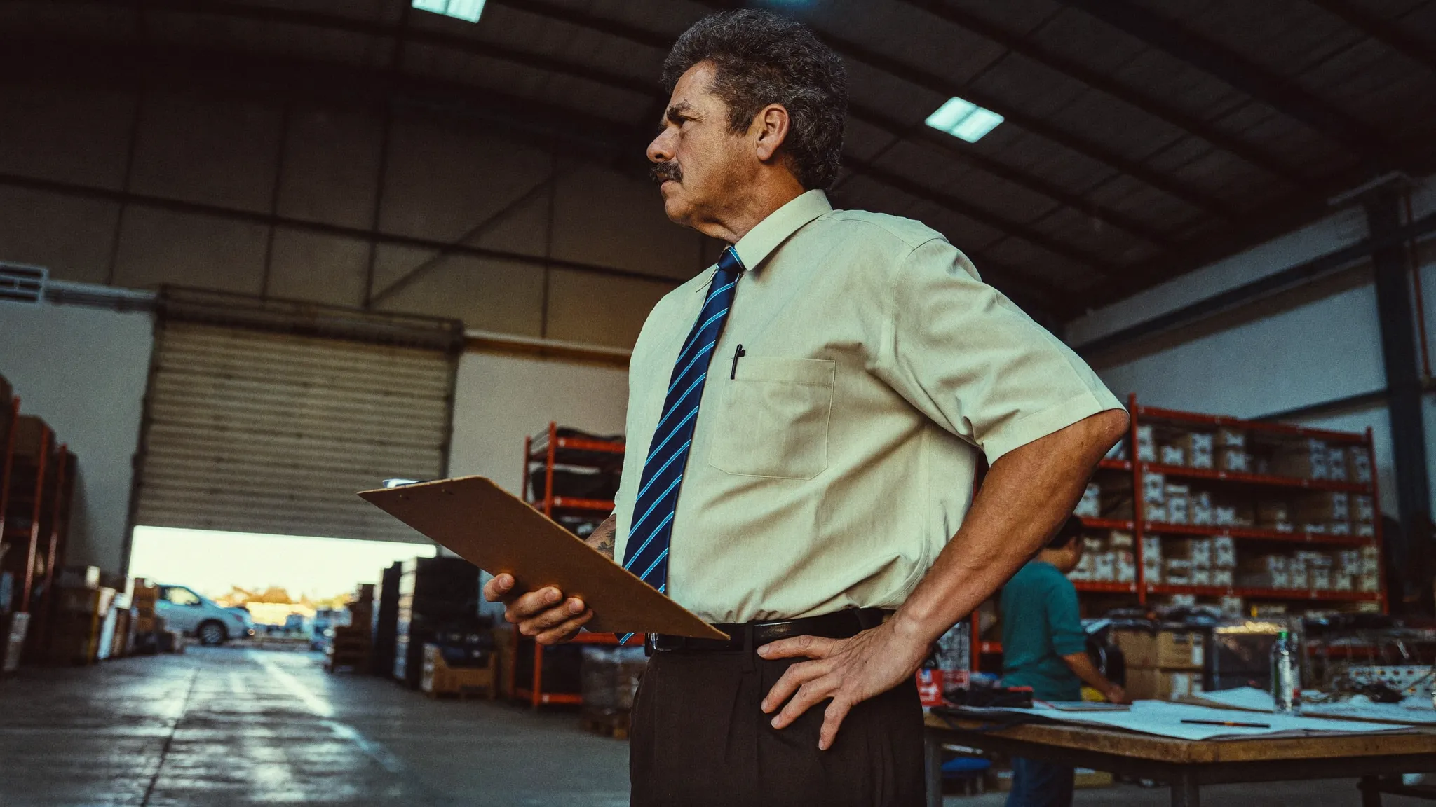 A business owner on the floor of his own warehouse late in the day